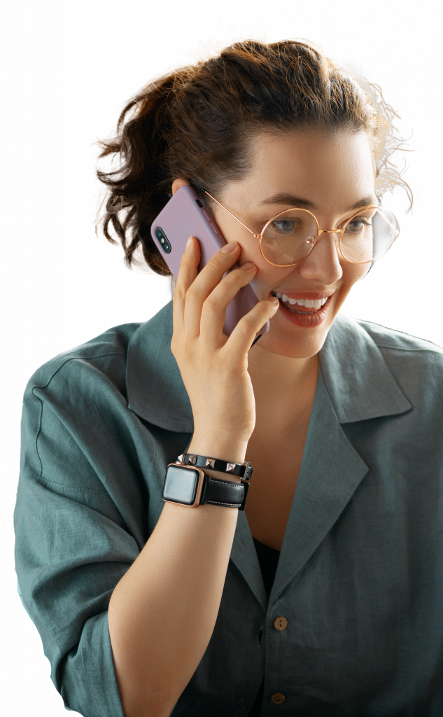 assistante en ligne , jeune femme brune, avec de fines lunette dorée, elle porte une chemise verte et tient son téléphone portable à son oreille droite, elle semble en train de travailler
