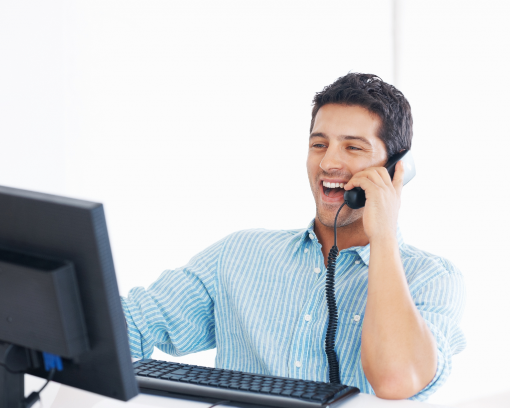 Assistant en ligne riant au téléphone, il est devant son ordinateur et travaille en tant qu'indépendant