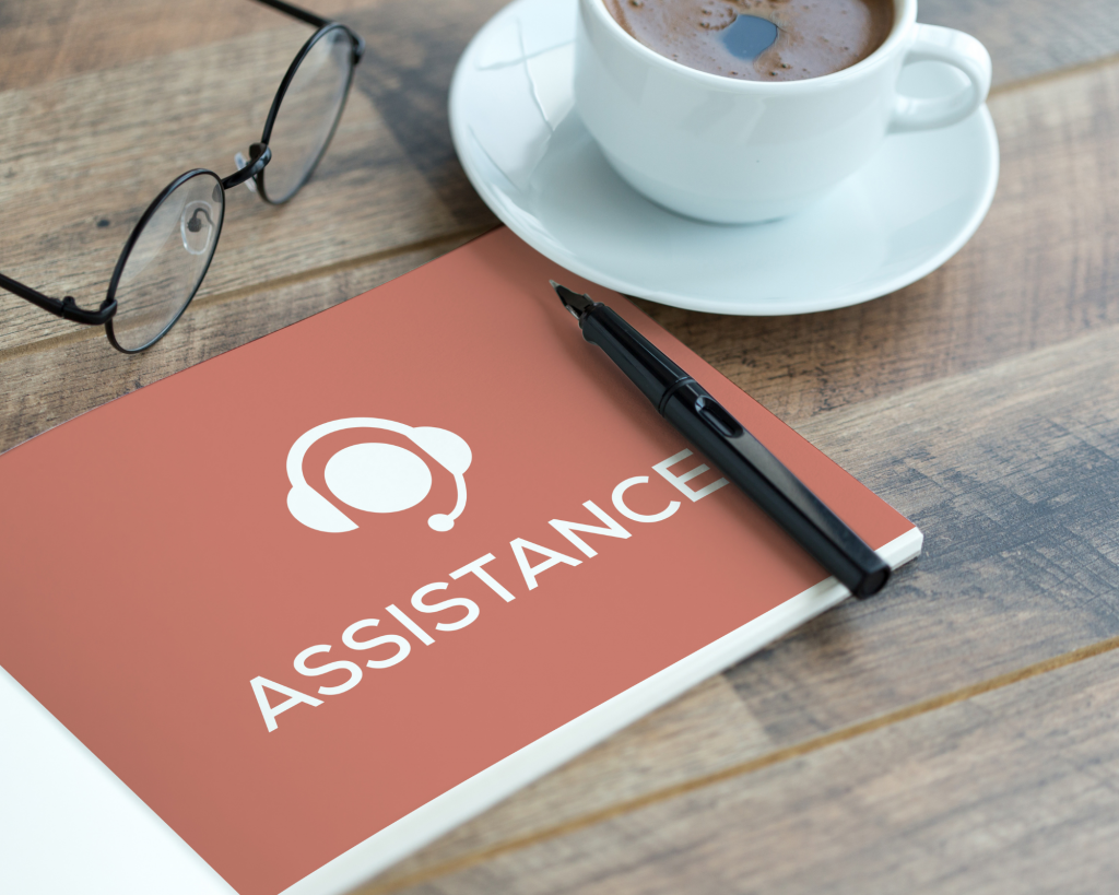 Dossier avec la mention assistance en titre, près d'une tasse de café et un paire de lunettes, ce dossier référence l'ensemble des compétences clés d'un bon assitant virtuel