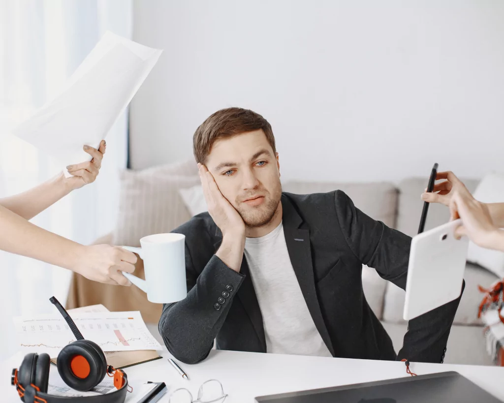 le plaisir de déléguer, pour gagner du temps et arrêre de perdre son temps, un homme, est à son bureau et plusieurs mains sont tendues vers lui pour lui passer une tasse, des dossiers et autre